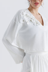 توب قصير بياقة V وتفاصيل وردية بارزة